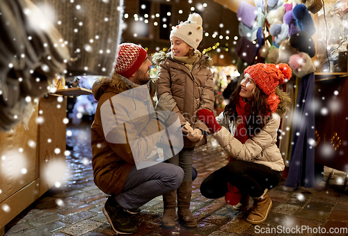 Image of happy family at christmas market in city