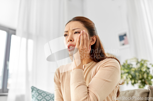 Image of asian woman suffering from toothache at home