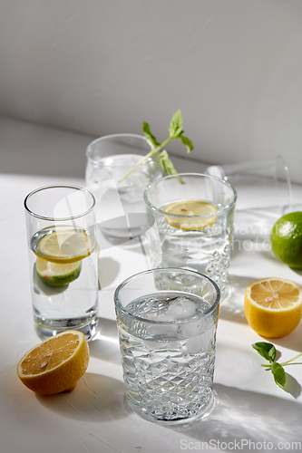 Image of glasses with lemon water and peppermint on table