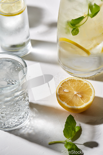 Image of glasses with lemon water and peppermint on table