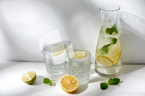 Image of glasses with lemon water and peppermint on table