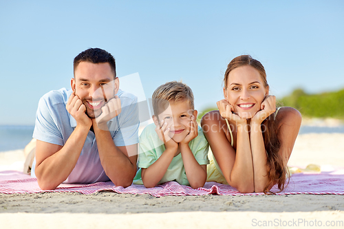 Image of happy family lying on summer beach