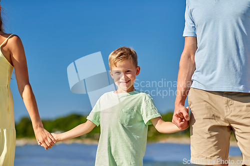 Image of happy family walking along summer beach