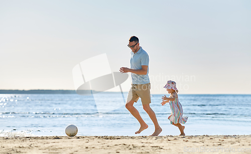 Image of happy father and daughter playing ball on beach