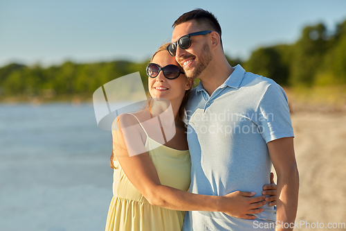 Image of happy couple hugging on summer beach