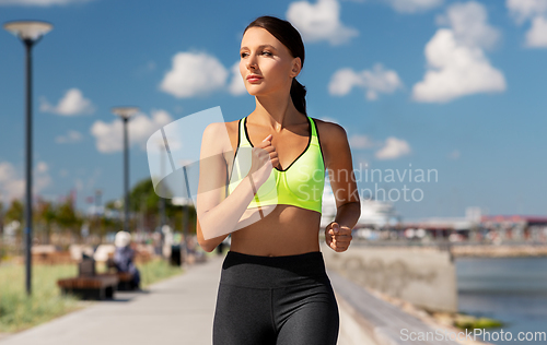 Image of young woman running at seaside