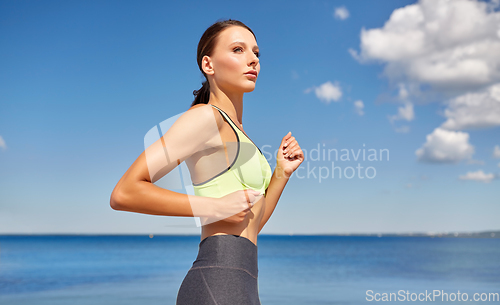 Image of young woman running at seaside