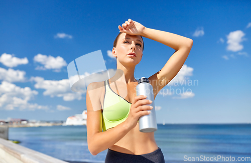 Image of woman drinking water from bottle after sports