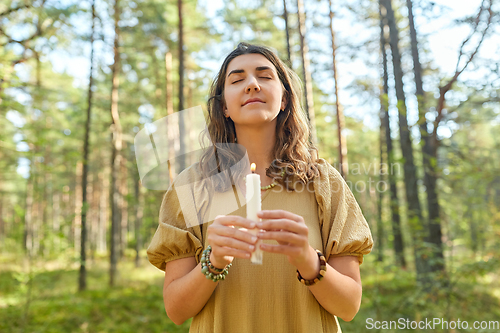 Image of woman or witch performing magic ritual in forest