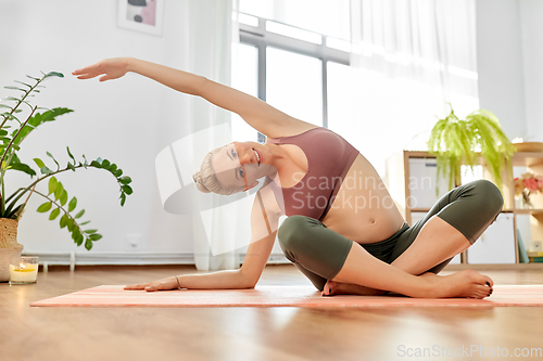 Image of happy pregnant woman doing yoga at home