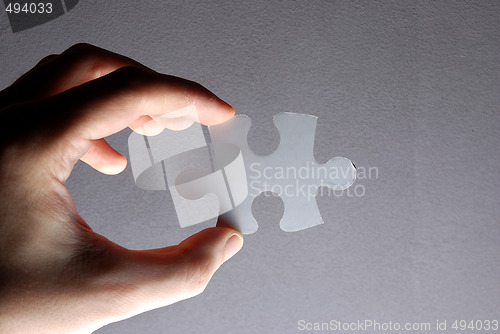 Image of Hand holding a puzzle piece