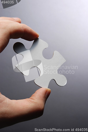 Image of Hand holding a puzzle piece