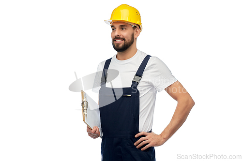 Image of happy worker or builder in helmet with clipboard