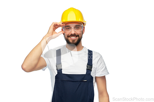 Image of happy male worker or builder in helmet and overall