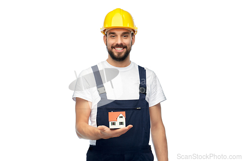 Image of happy male builder holding model of living house