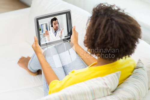 Image of woman having video call with doctor on tablet pc