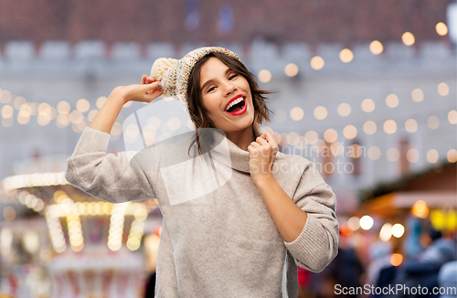 Image of happy woman in hat and sweater at christmas market