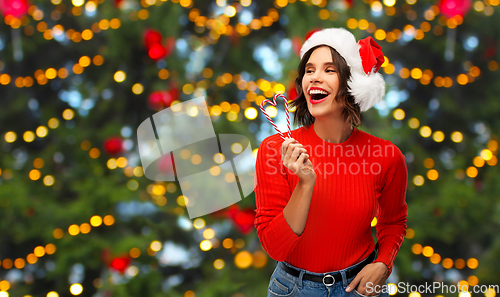 Image of happy young woman in santa hat on christmas