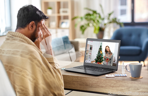 Image of sick man having video call with woman on christmas