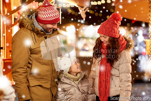 Image of happy family at christmas market in city