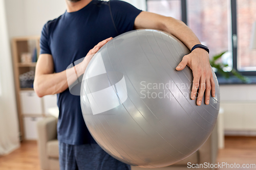 Image of close up of man with fitness ball at home