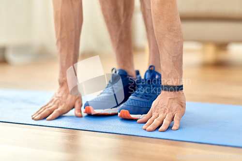 Image of close up of male hands and feet on exercise mat