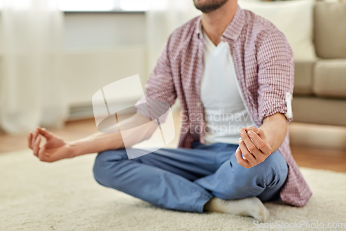 Image of close up of man meditating at home