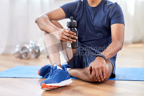 Image of indian man drinking water after training at home