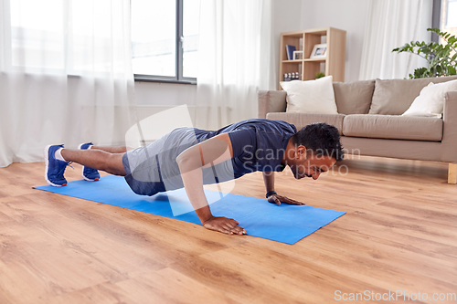 Image of indian man doing push ups at home