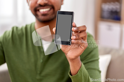 Image of close up of smiling man showing smartphone at home