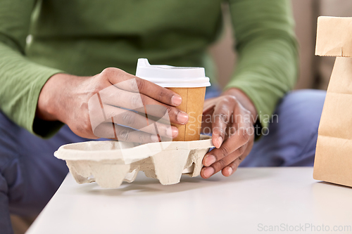 Image of close up of man with takeaway coffee and food