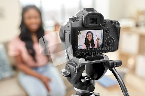 Image of female blogger with camera video blogging at home