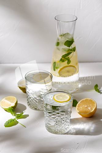 Image of glasses with lemon water and peppermint on table