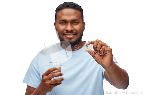 Image of african american man with pill and glass of water