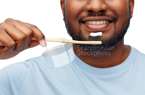 Image of smiling african man with toothbrush cleaning teeth