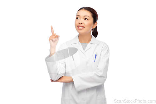 Image of happy asian female doctor pointing finger up