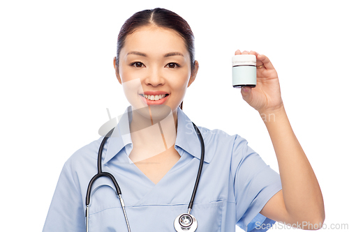 Image of smiling asian female doctor or nurse with medicine