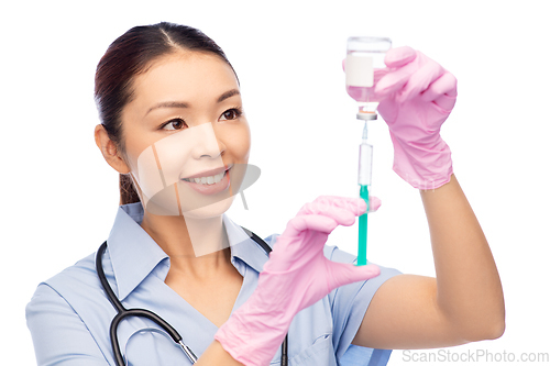 Image of happy asian female nurse with medicine and syringe