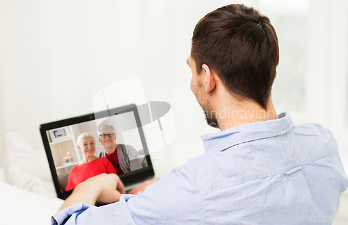 Image of man with laptop having video call with his family