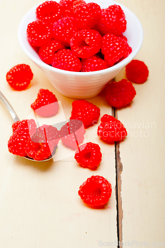 Image of bunch of fresh raspberry on a bowl and white table