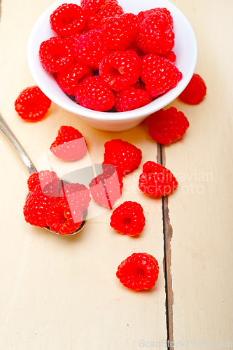 Image of bunch of fresh raspberry on a bowl and white table