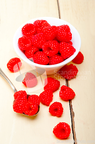 Image of bunch of fresh raspberry on a bowl and white table