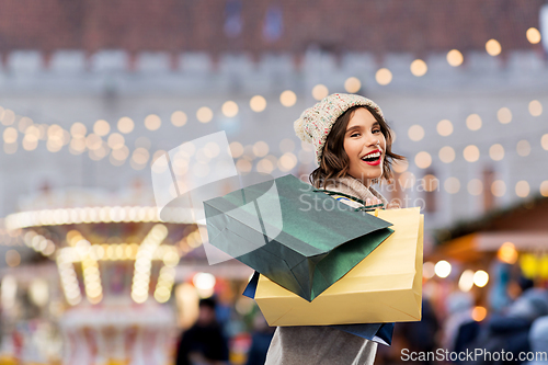 Image of happy woman with shopping bags at christmas market