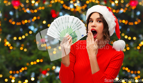 Image of surprised woman with money on christmas