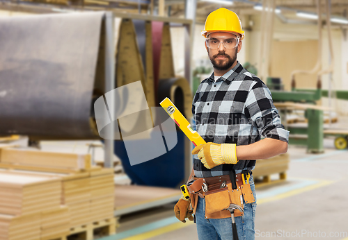 Image of male worker or builder in helmet with level