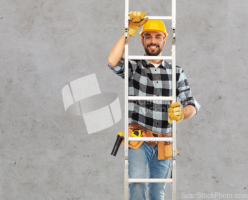 Image of happy male builder in helmet climbing up ladder