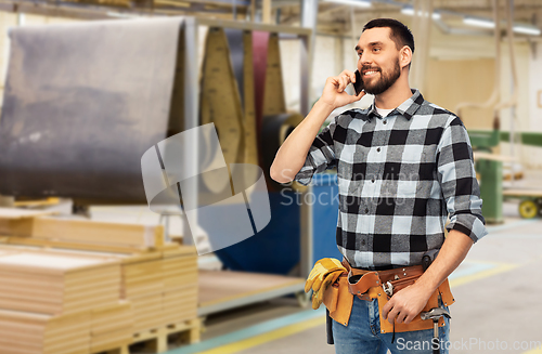 Image of builder in helmet calling on smartphone