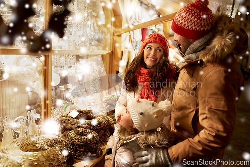 Image of happy family at christmas market in city