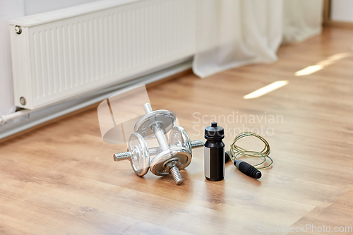 Image of dumbbells, skipping rope and bottle on floor