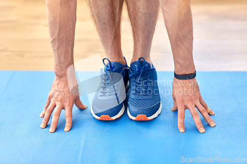 Image of close up of male hands and feet on exercise mat